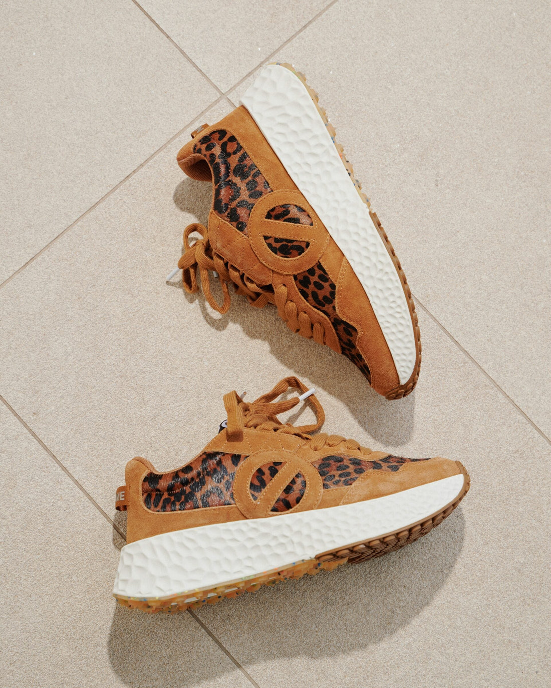 Sneakers leopardate color cuoio su piastrelle
