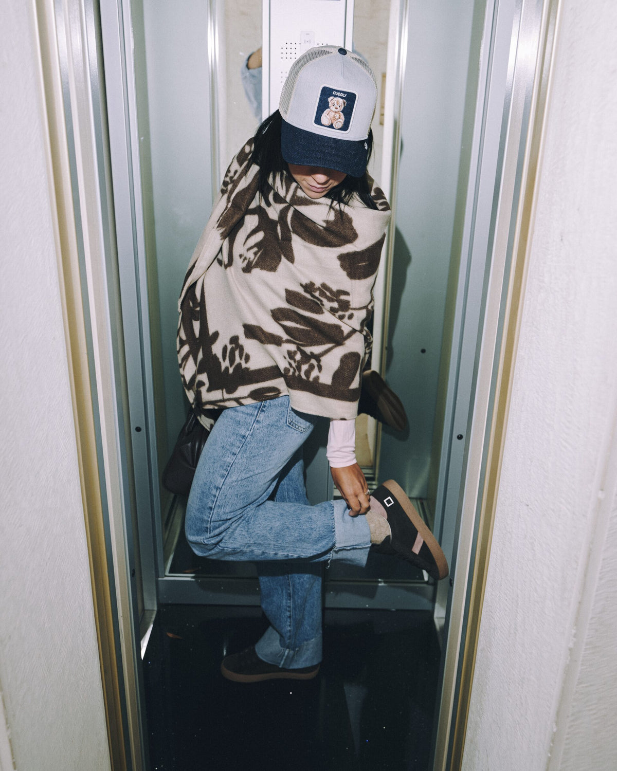 Cappellino e sneakers in un ascensore