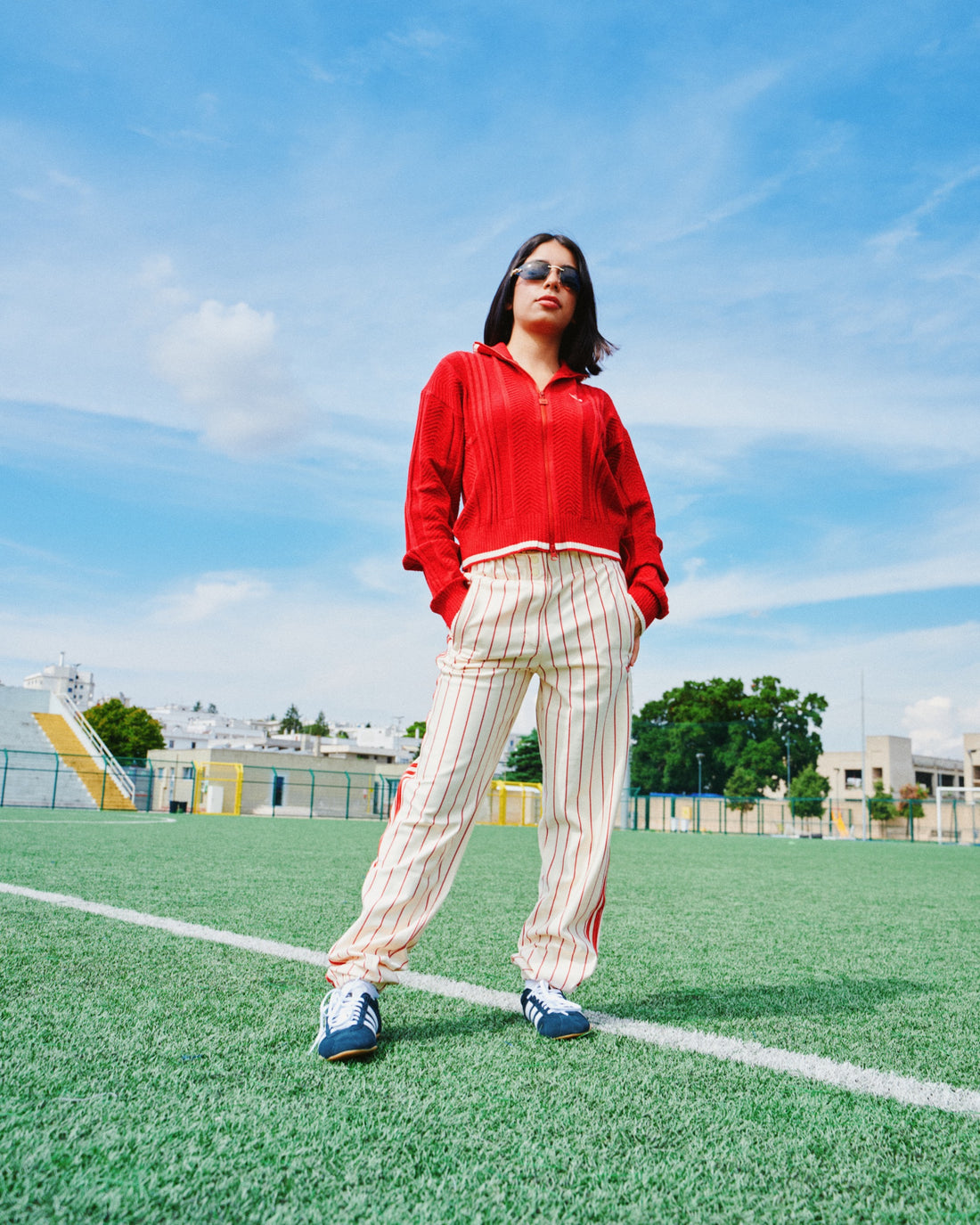 Ragazza con maglia rossa e pantaloni beige su un campo da calcio